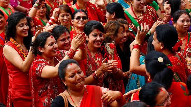 Nepali women wearing red saris and traditional jewellery during the Teej festival